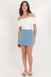 Falda short corto cruzado de denim, corte en a, cintura alta, cortes decorativos con abertura y cierre frontal con botón en contraste.