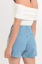 Falda short corto cruzado de denim, corte en a, cintura alta, cortes decorativos con abertura y cierre frontal con botón en contraste.
