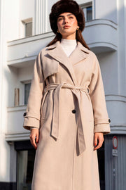 Abrigo largo de doble cruce de botón en contraste, manga larga con trabilla y botón en puños, con solapa, bata decorativa frontal, bolsillos delanteros con vivos, trabillas y cinturón amarrable del mismo tejido.