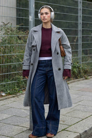 Abrigo largo de doble cruce de botón en contraste, manga larga con trabilla y botón en puños, con solapa, bata decorativa frontal, bolsillos delanteros con vivos, trabillas y cinturón amarrable del mismo tejido.