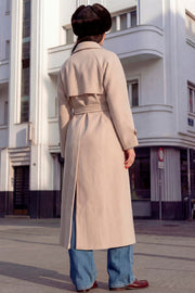 Abrigo largo de doble cruce de botón en contraste, manga larga con trabilla y botón en puños, con solapa, bata decorativa frontal, bolsillos delanteros con vivos, trabillas y cinturón amarrable del mismo tejido.