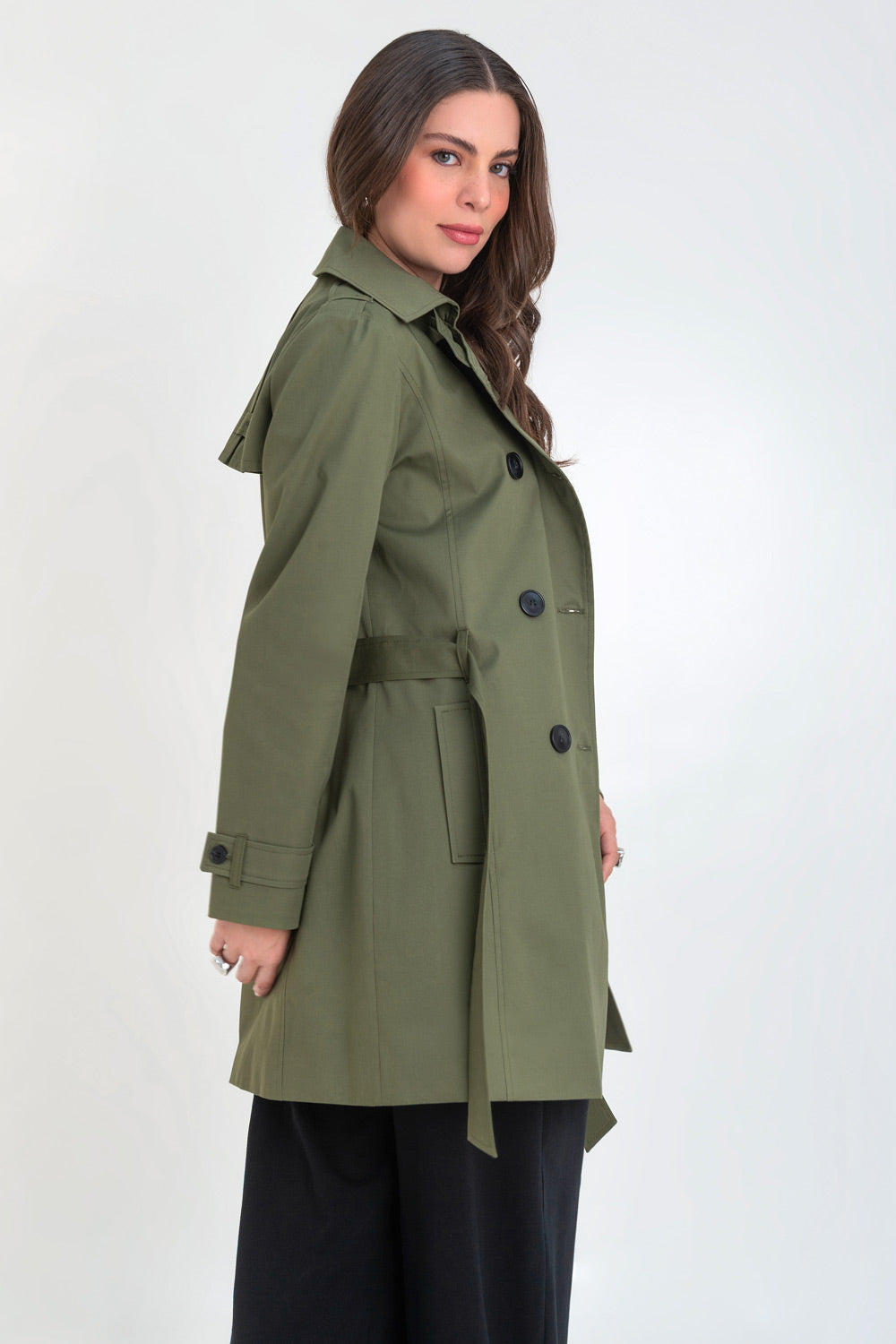 Abrigo trench corto de fit recto, con cuello solapa, bolsillos delanteros con vivos, detalle de bata trasera y manga larga. Trabillas, cinturón amarrable del mismo tejido y cierre frontal con doble cruce de botones en contraste. Detalle de trabilla y botón en hombros, bata trasera, cuello y puños.