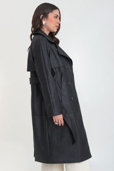 Abrigo trench largo de efecto piel, fit recto, manga larga, con solapa y bata en espalda, cortes decorativos frontales, trabillas y cinturón del mismo tejido con hebilla en contraste. Cierre frontal con doble cruce de botones en contraste.