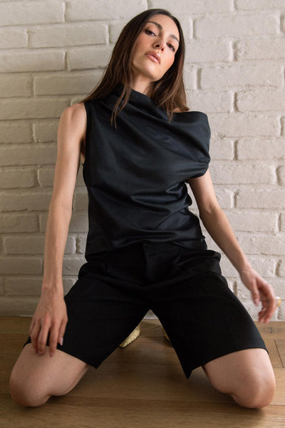 Bermuda de cintura baja con pretina, pinzas frontales, raya frontal, bolsillos delanteros y vivos decorativos posteriores. Cierre frontal con broche y cremallera oculta.