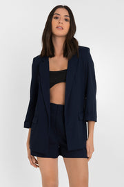 Blazer abierto de fit recto, con solapa y hombreras, manga 3/4 con doblez en puños, bolsillos delanteros con cartera y bajo curveado frontal.