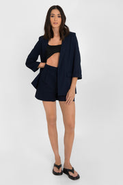Blazer abierto de fit recto, con solapa y hombreras, manga 3/4 con doblez en puños, bolsillos delanteros con cartera y bajo curveado frontal.