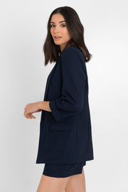 Blazer abierto de fit recto, con solapa y hombreras, manga 3/4 con doblez en puños, bolsillos delanteros con cartera y bajo curveado frontal.