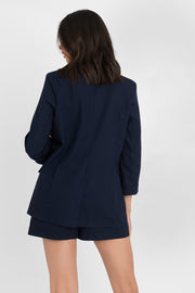 Blazer abierto de fit recto, con solapa y hombreras, manga 3/4 con doblez en puños, bolsillos delanteros con cartera y bajo curveado frontal.