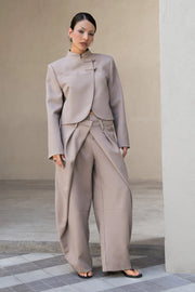 Blazer corto cruzado de manga larga con abertura en puños, cuello mao, vivo decorativo frontal, detalle de botones decorativos frontales y bajo curveado.
