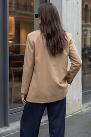 Blazer cruzado de fit oversized, con solapa y hombreras, manga larga, vivo frontal, bolsillos delanteros con cartera. Cierre frontal con cruce de botones.