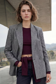 Blazer cruzado de fit oversized, con solapa y hombreras, manga larga, bolsillos delanteros con cartera y cierre frontal con cruce de botones.