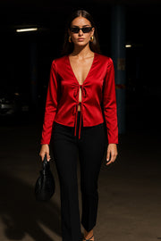 Blusa satinada abierta de fit fluido, escote v, manga larga amplia con abertura en puños y cierre frontal con lazo amarrable.