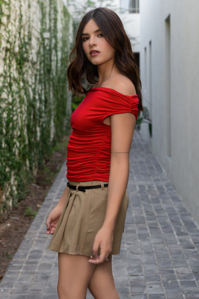 Blusa de fit ajustado, manga corta seguida con plisados en laterales, hombros descubiertos, plisados en costados y escote recto.
