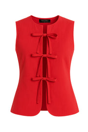 Blusa de fit ajustado, cuello redondo, sin mangas y cierre frontal con lazos amarrables. Detalle de bajo curveado frontal.