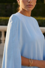 Blusa tipo túnica asimétrica, de cuello redondo, con hombreras, manga corta seguida, fit fluido y bajo asimétrico.