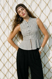Blusa de fit ajustado, estampado rayas, cuello mao, sin mangas, pinzas frontales y peplum con olanes en bajo. Cierre frontal con botones alamares.