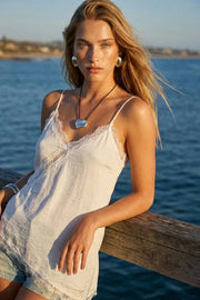 Blusa fluida larga de tirantes delgados ajustables, escote v con escote decorativo en contraste, cut out diagonal y bajo asimétrico frontal.