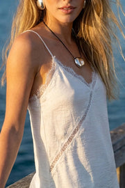 Blusa fluida larga de tirantes delgados ajustables, escote v con escote decorativo en contraste, cut out diagonal y bajo asimétrico frontal.