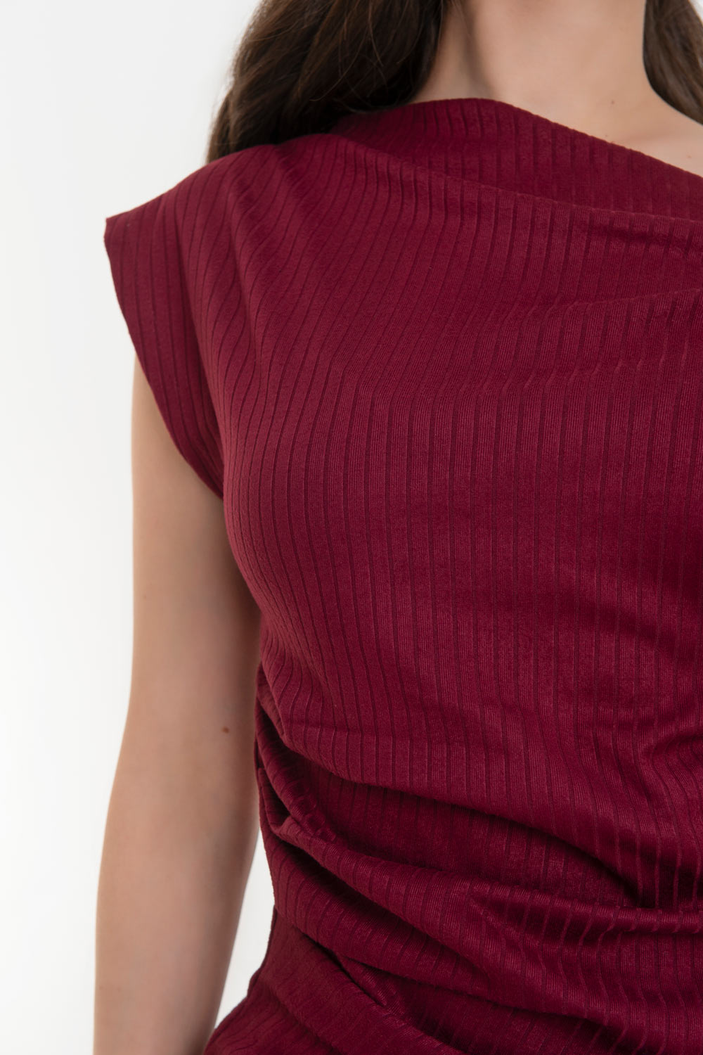 Blusa canalé asimétrica de fit ajustado, manga corta seguida con plisados en hombros y escote diagonal con hombro descubierto. Detalles plisados en costados.