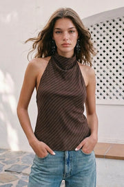 Blusa de estampado rayas, cuello halter fluido, escote en espalda con lazo amarrable posterior, cierre con botón y ojal.