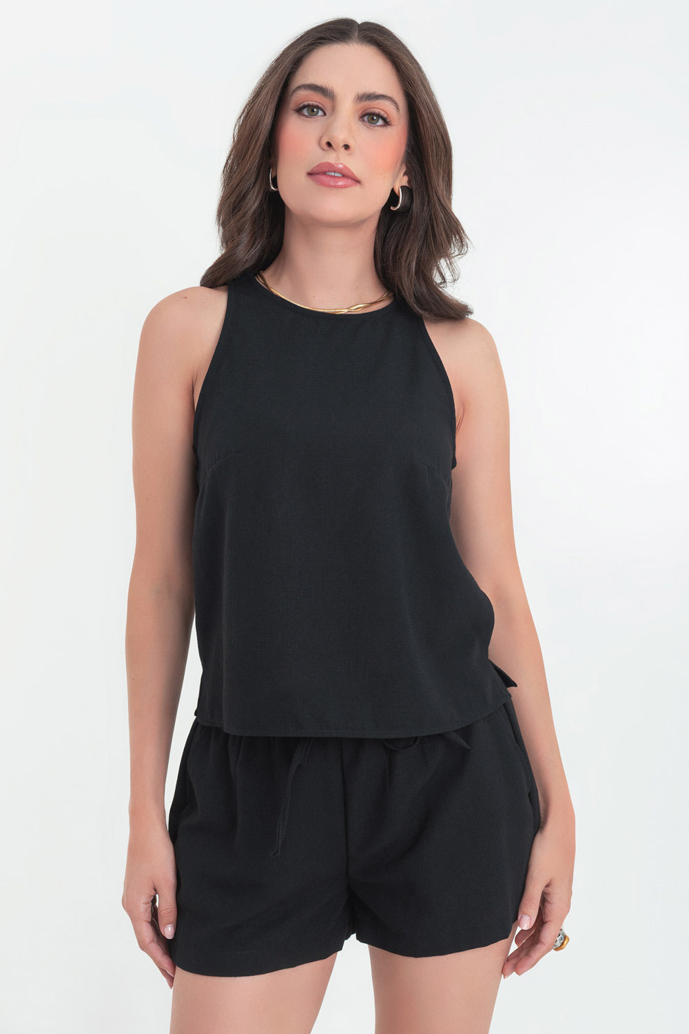 Blusa corta básica de fit recto, cuello redondo, sin mangas, aberturas laterales en bajo, cierre posterior con botón y ojal.