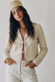 Blusa corta de fit fluido, manga larga, escote v con solapa y cierre frontal con lazos amarrables.