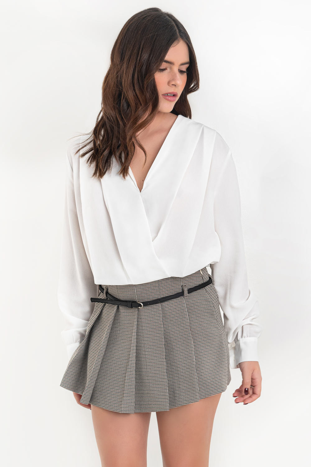 Blusa corta de fit fluido, escote v cruzado, manga larga abullonada con puño abotonado, plisados en hombros y bajo con rib elástico.