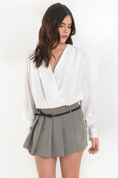 Blusa corta de fit fluido, escote v cruzado, manga larga abullonada con puño abotonado, plisados en hombros y bajo con rib elástico.