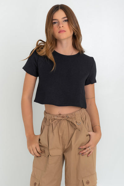 Blusa corta de fit ligeramente oversized, de cuello redondo, manga corta y cierre posterior con botón y ojal.