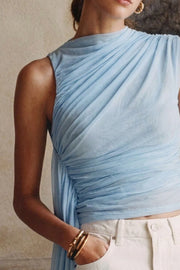 Blusa de mesh con plisados decorativos frontales, cuello mock, sin manags, y detalle decorativo lateral.