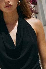 Blusa de cuello halter, escote fluido frontal, sin mangas y escote en espalda.