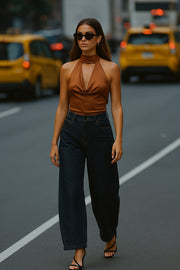 Blusa corta de cuello alto halter con lazo amarrable posterior, escote fluido con cut out frontal y en espalda.