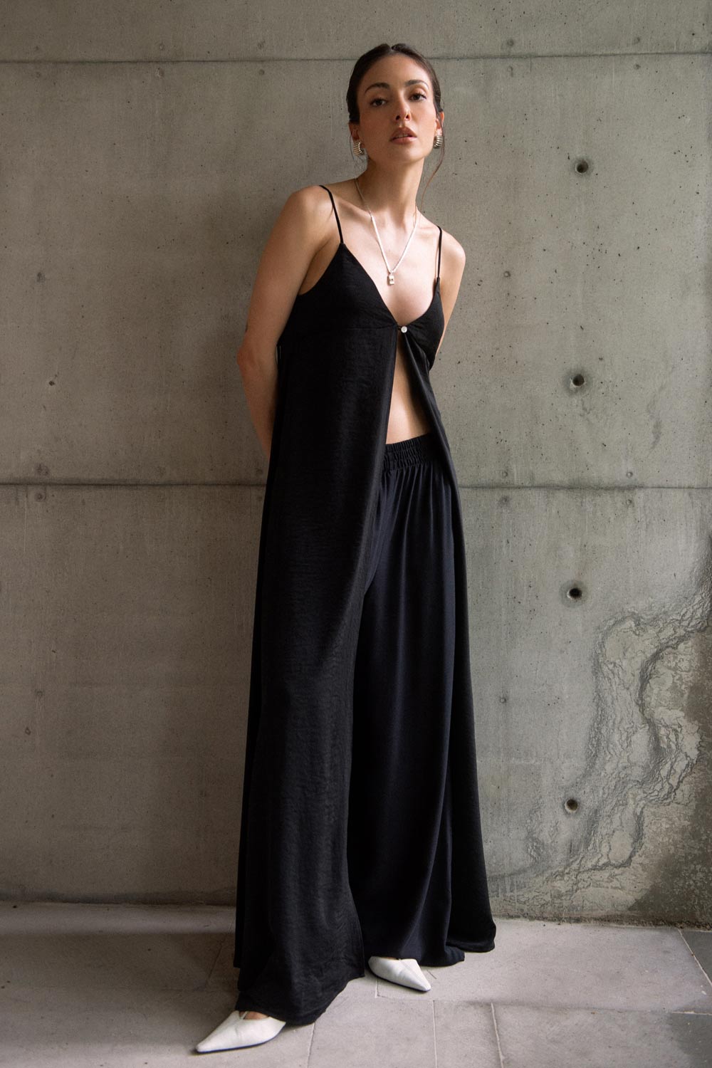 Blusa larga de fit fluido, tirantes delgados con nudo ajustable, escote v con cortes, abertura frontal y cierre con botón.