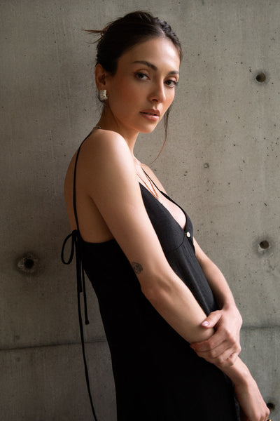 Blusa larga de fit fluido, tirantes delgados con nudo ajustable, escote v con cortes, abertura frontal y cierre con botón.