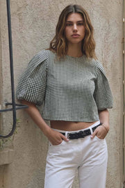 Blusa corta de estampado cuadros, fit recto, cuello redondo, manga corta amplia globo con volumen en borde, detalle de pinza de amplitud en espalda y cierre posterior con botón y ojal.