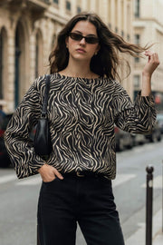 Blusa estampada de fit fluido, manga amplia 3/4, cuello barco y botones decorativos en hombro.
