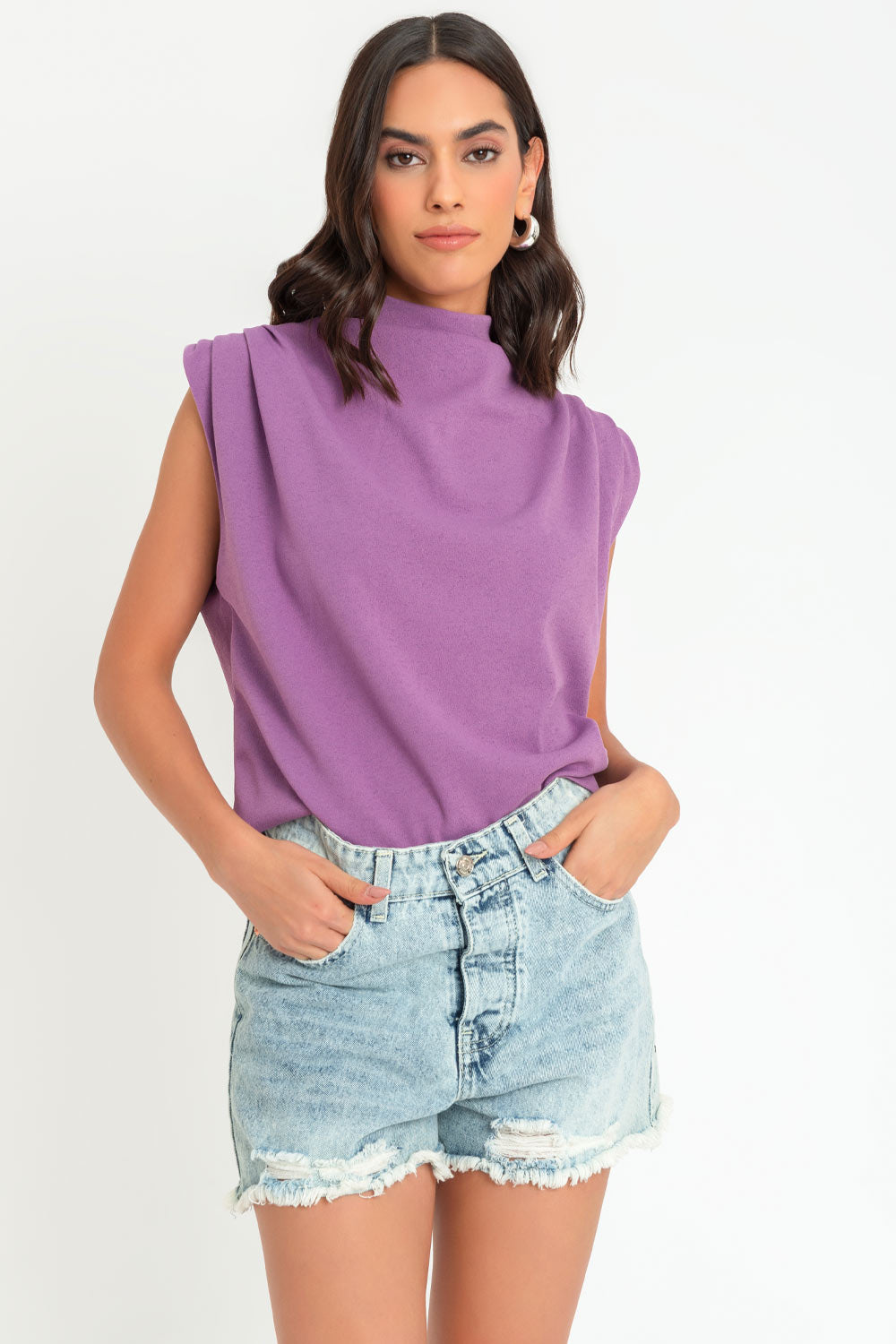 Blusa de fit oversized, sin mangas y cuello alto con detalles plisados en hombros.