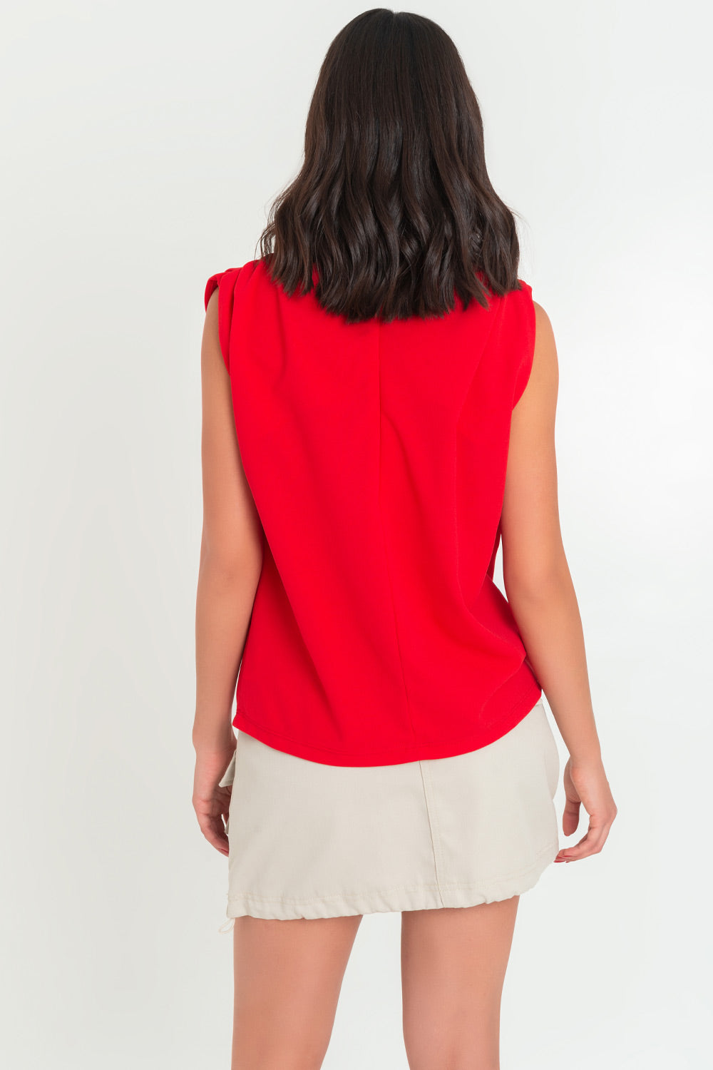 Blusa de fit oversized, sin mangas y cuello alto con detalles plisados en hombros.