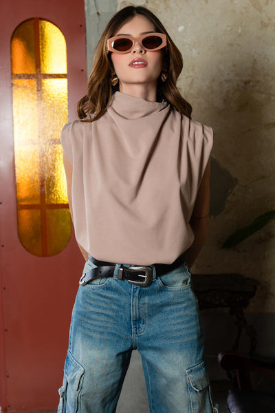 Blusa de fit oversized, sin mangas y cuello alto con detalles plisados en hombros.