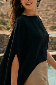 Blusa tipo túnica satinada asimétrica, de cuello redondo, con hombreras, una manga corta seguida, fit fluido y bajo asimétrico. Cierre posterior con cremallera oculta.