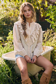 Blusa de fit fluido, estampado rayas, manga larga globo con rib elástico en puños, cuello mao y detalle decorativo frontal con olanes.