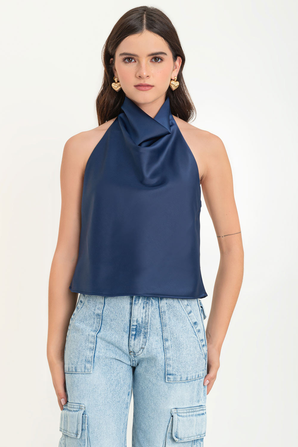 Blusa satinada de cuello halter con escote fluido, sin mangas y escote en espalda. Cierre posterior con botón y ojal.