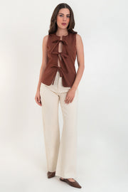 Blusa de fit ajustado, cuello redondo, sin mangas y cierre frontal con lazos amarrables. Detalle de bajo curveado frontal.