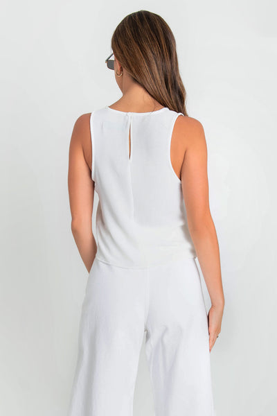 Blusa sin mangas de fit ligeramente oversized, cuello redondo y cierre posterior con botón y ojal.