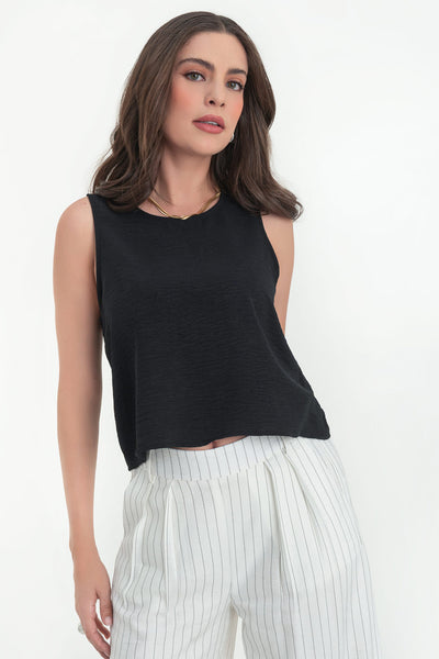 Blusa sin mangas de fit ligeramente oversized, cuello redondo y cierre posterior con botón y ojal.