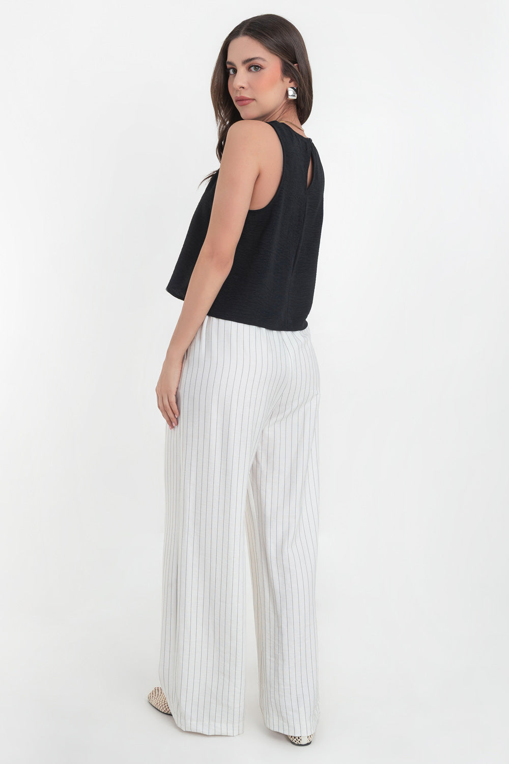 Blusa sin mangas de fit ligeramente oversized, cuello redondo y cierre posterior con botón y ojal.