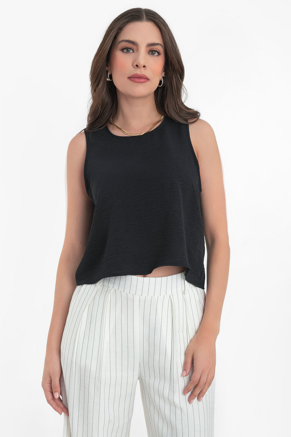 Blusa sin mangas de fit ligeramente oversized, cuello redondo y cierre posterior con botón y ojal.
