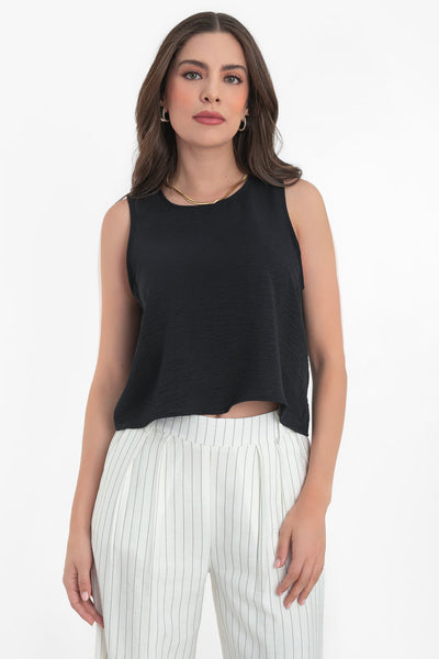 Blusa sin mangas de fit ligeramente oversized, cuello redondo y cierre posterior con botón y ojal.