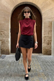 Blusa de fit oversized, sin mangas y cuello alto con detalles plisados en hombros.