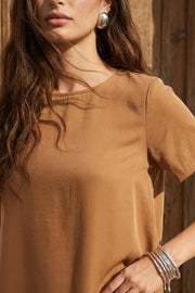 Blusa de fit recto, manga corta, cuello redondo y bajo diagonal asimétrico.